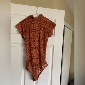 Fashion Nova lace bodysuit size Small. Ties up the entire back. Never worn.